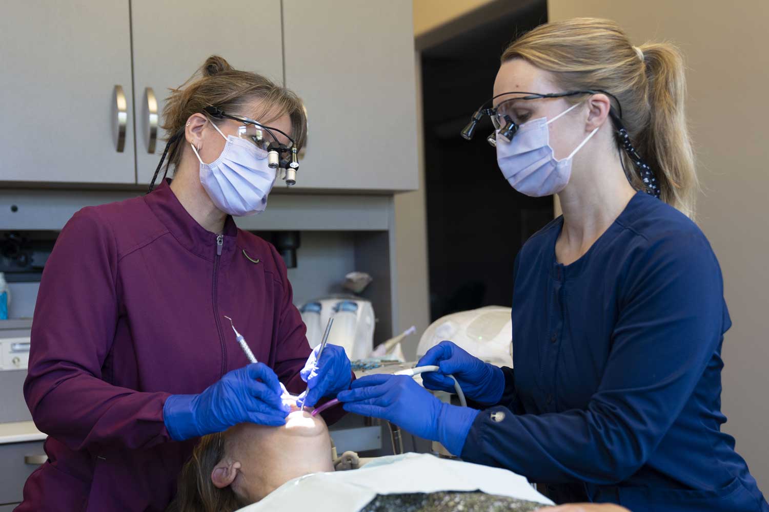 Dental hygienists working on a patient.