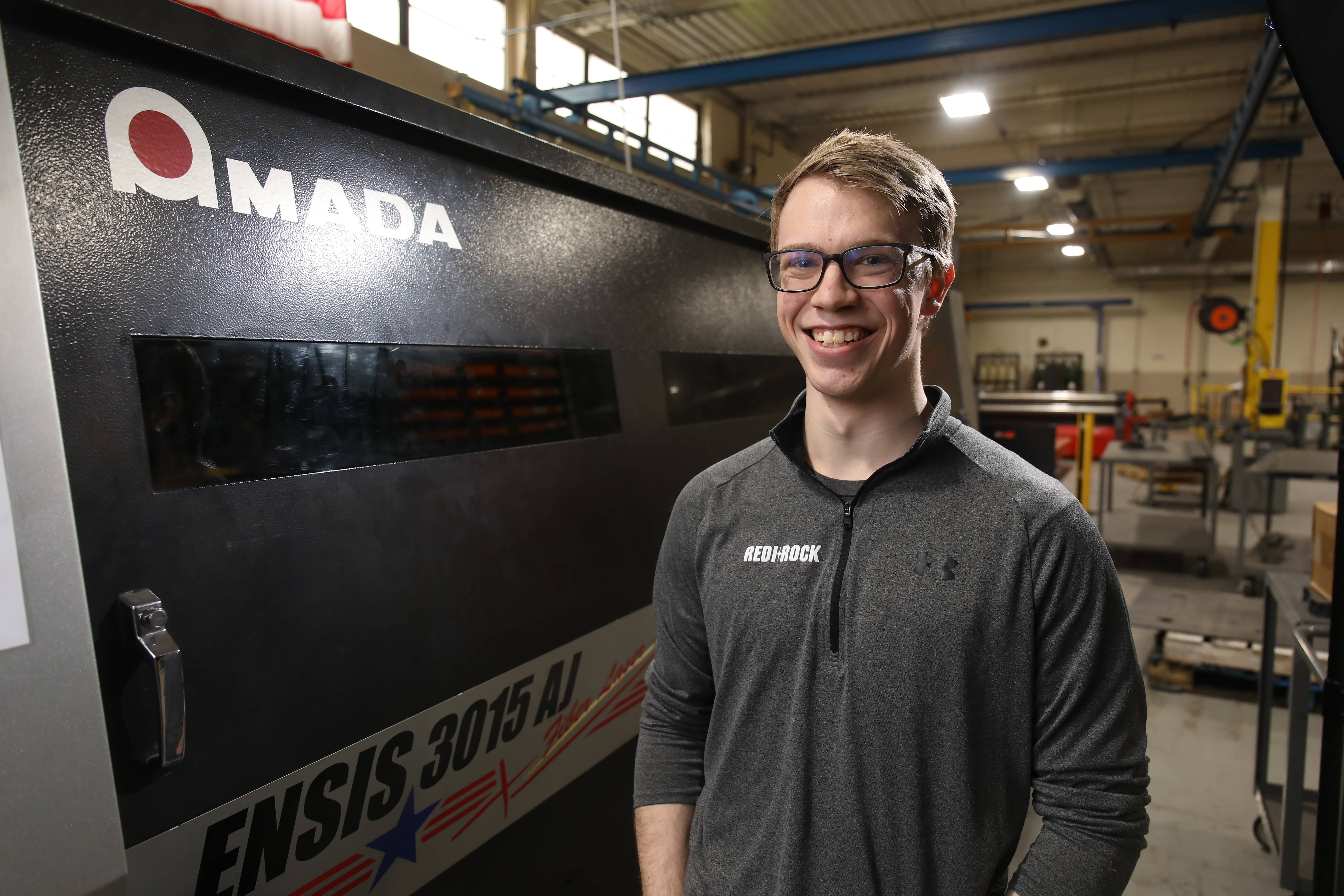 Man smiling in front of machinery