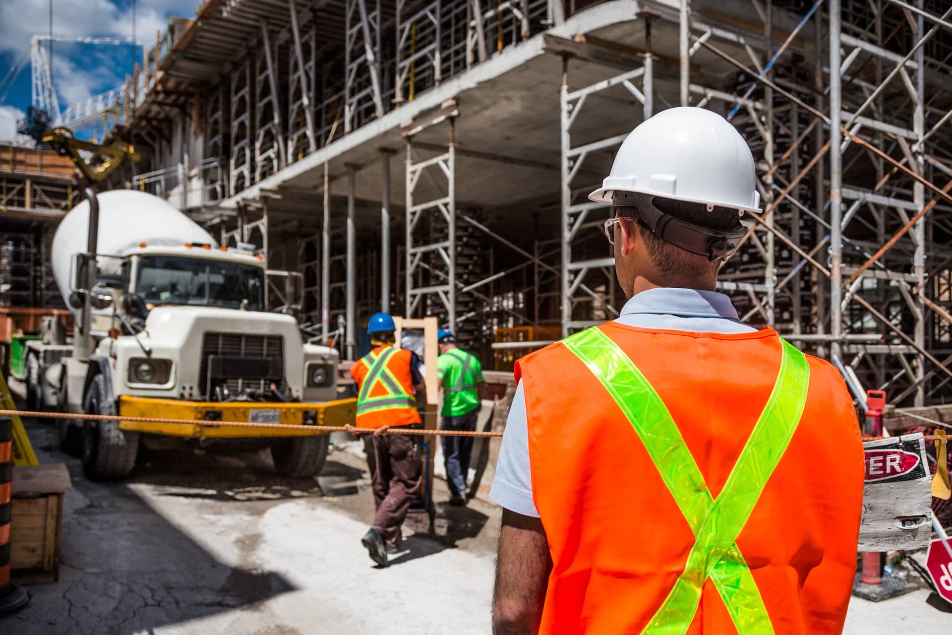 Construction workers in safety gear working at an active building site, representing skilled trades training