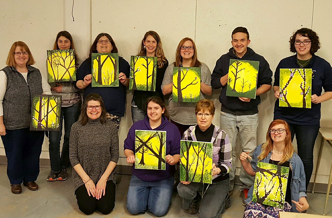 Group of Phi Theta Kappa members holding similar paintings