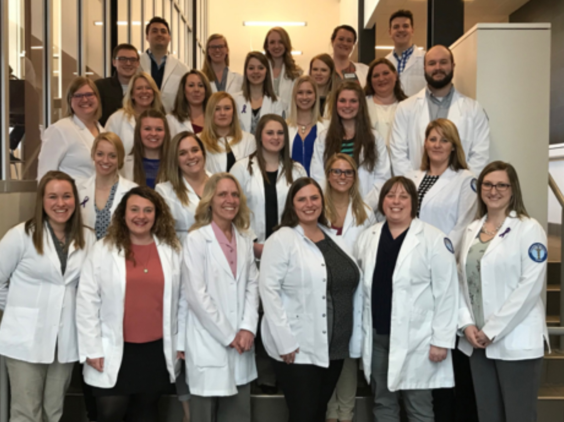 Students in a group wearing lab coats 