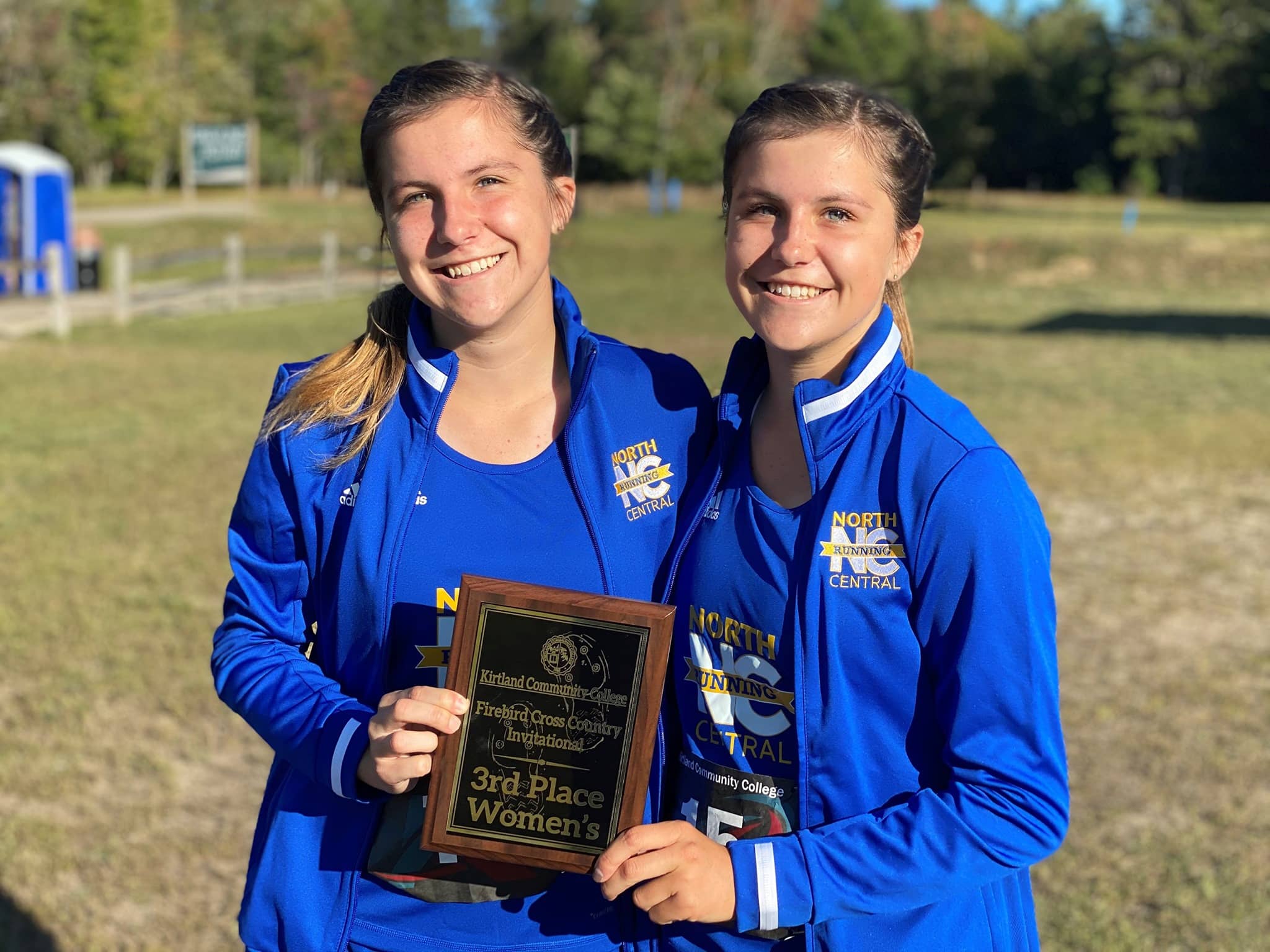 Two female runners holding trophy