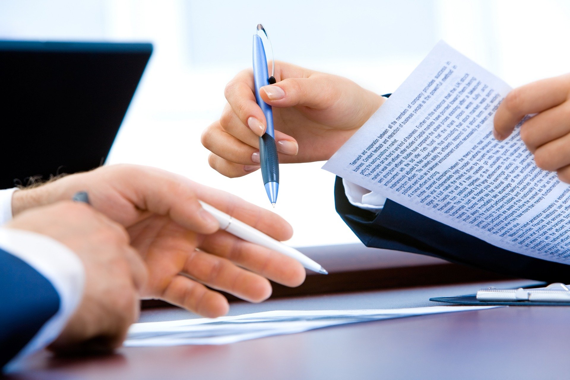 Office scene with hand holding pen and paper