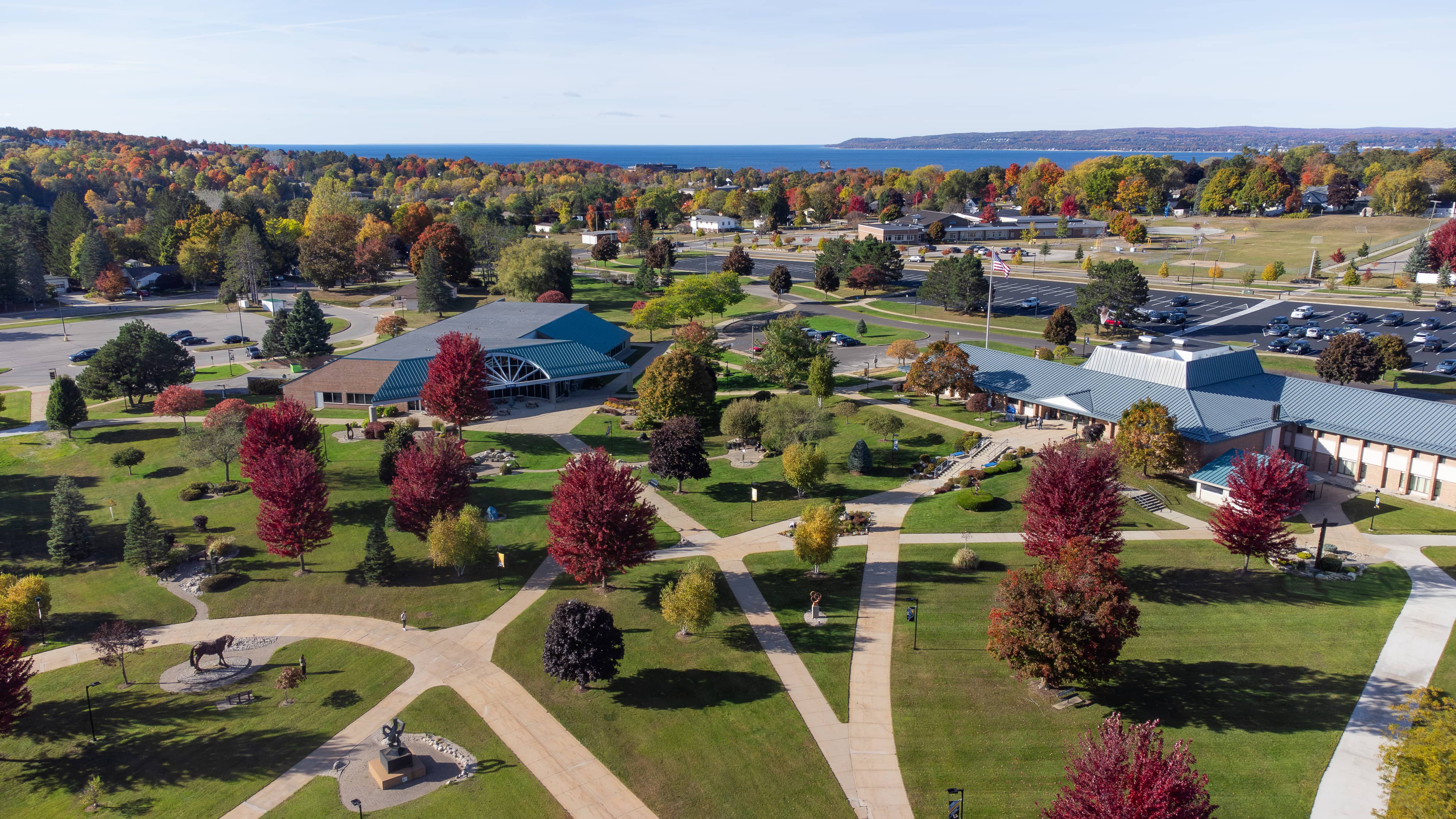 Aerial view of North Central Michigan College’s Petoskey campus in autumn, with red and orange trees surrounding campus buildings and walkways