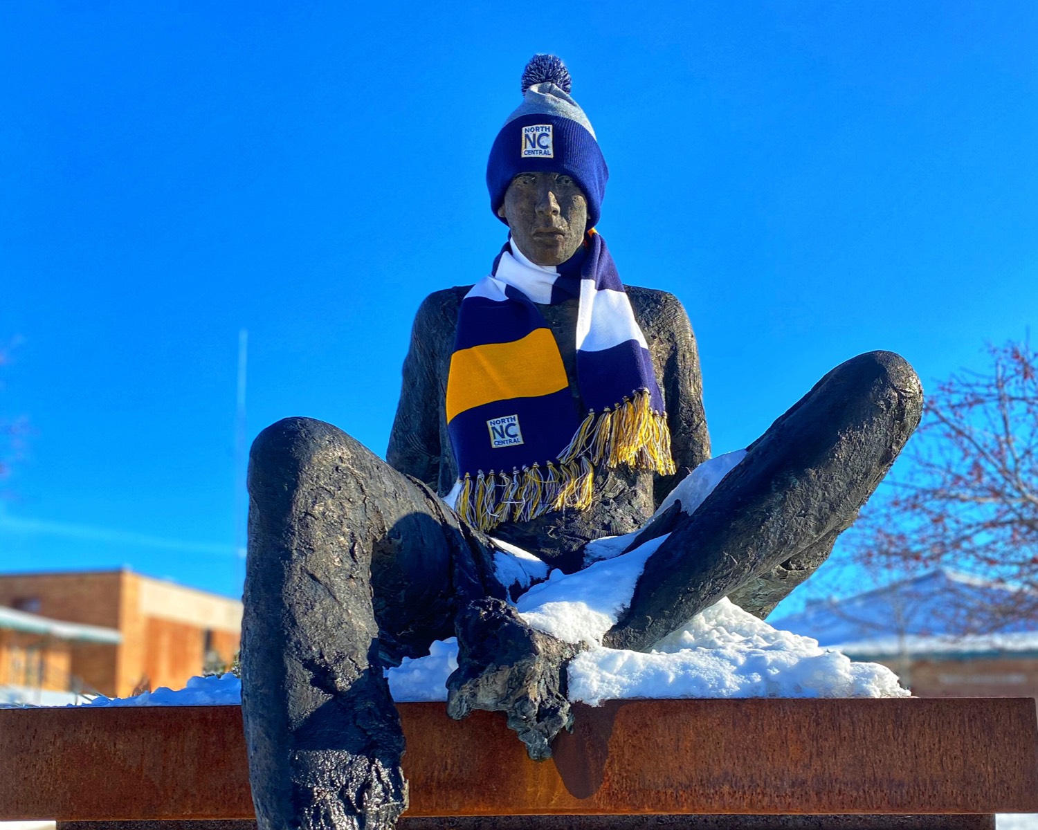 Statue on campus wearing hat and scarf.