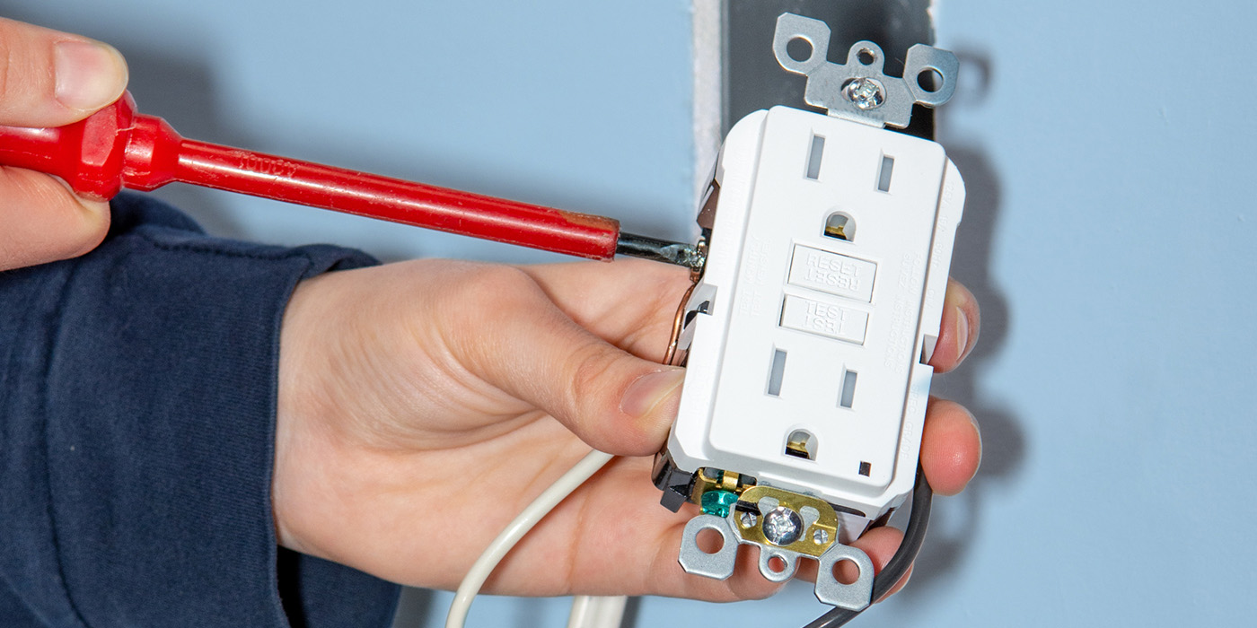 photo of a person holding an electical outlet