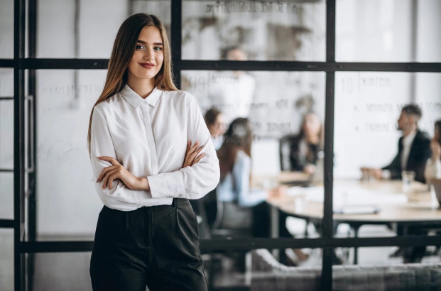 Woman posing with folded arms in front of team meeting