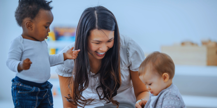 Smiling adult woman with two toddlers