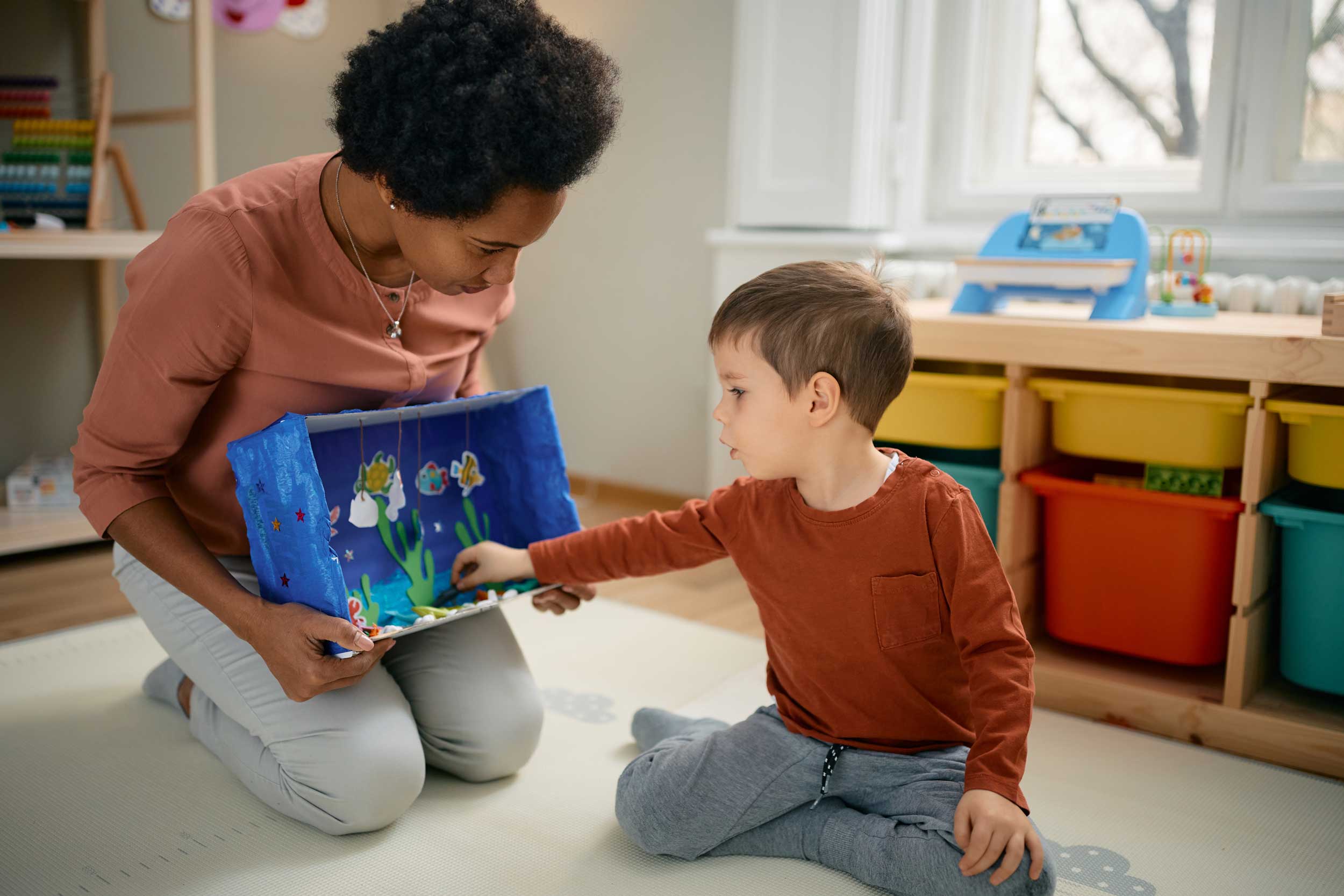 childcare worker sitting with a child