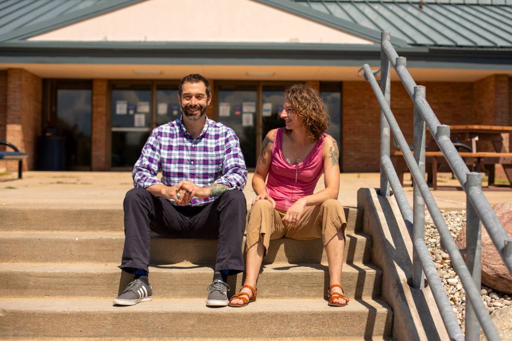 Two people sitting on stairs smiling