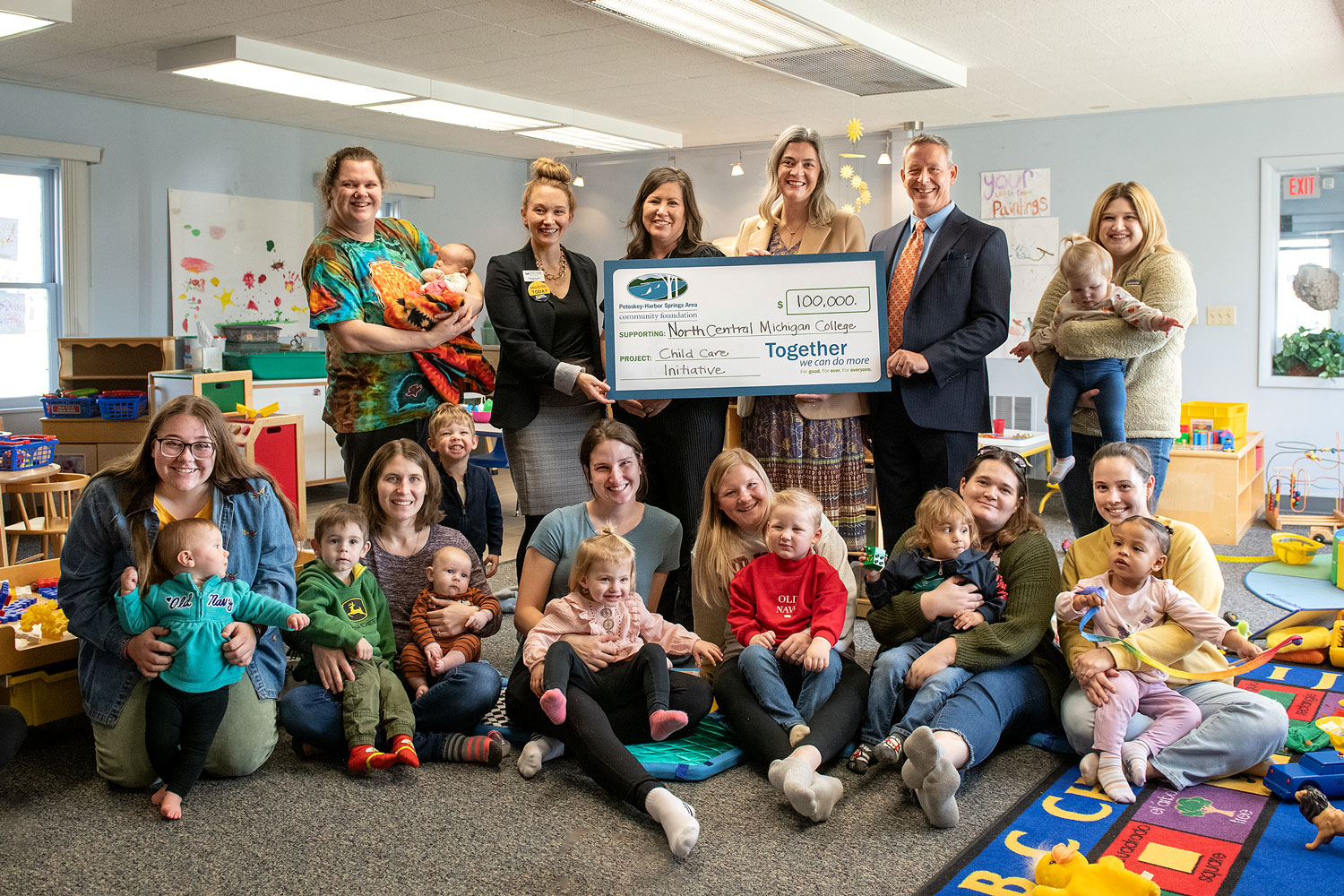 Photo of smiling adults and children at a check presentation