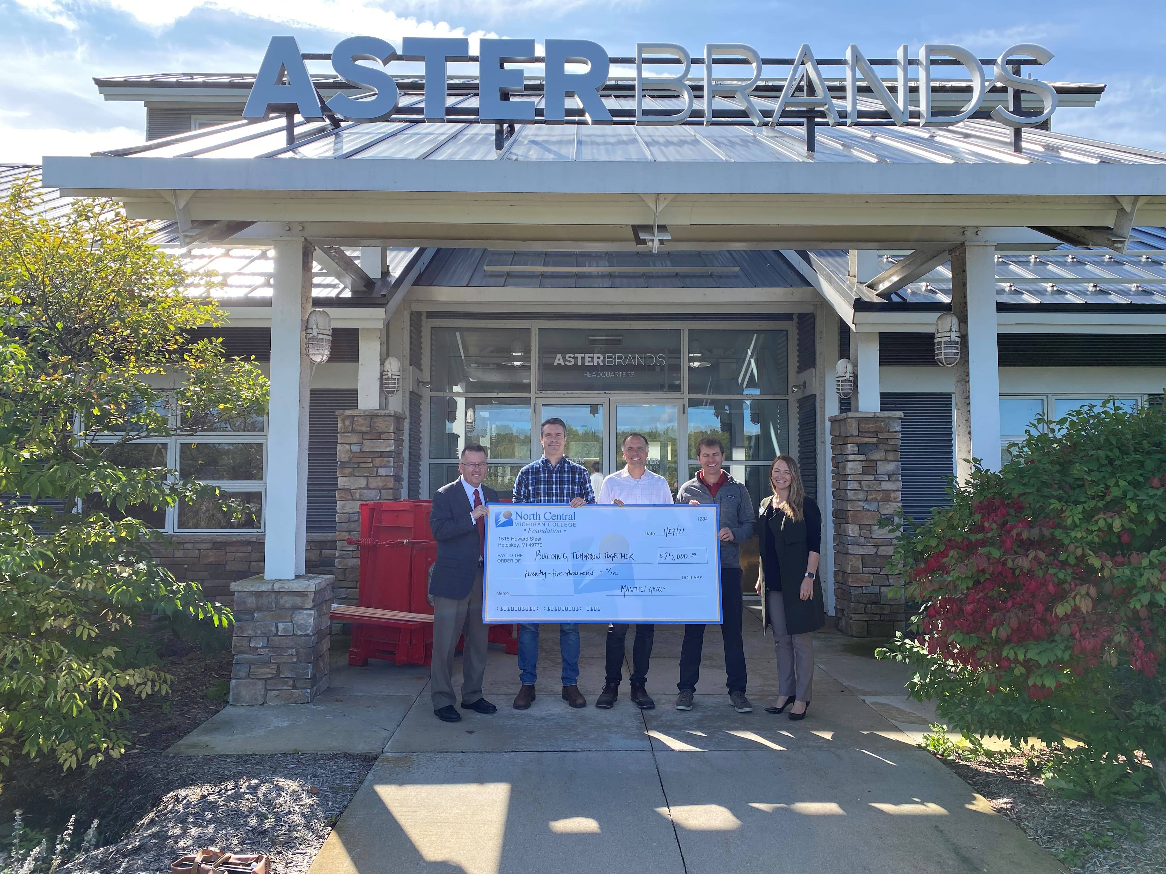 Five people at a check presentation event