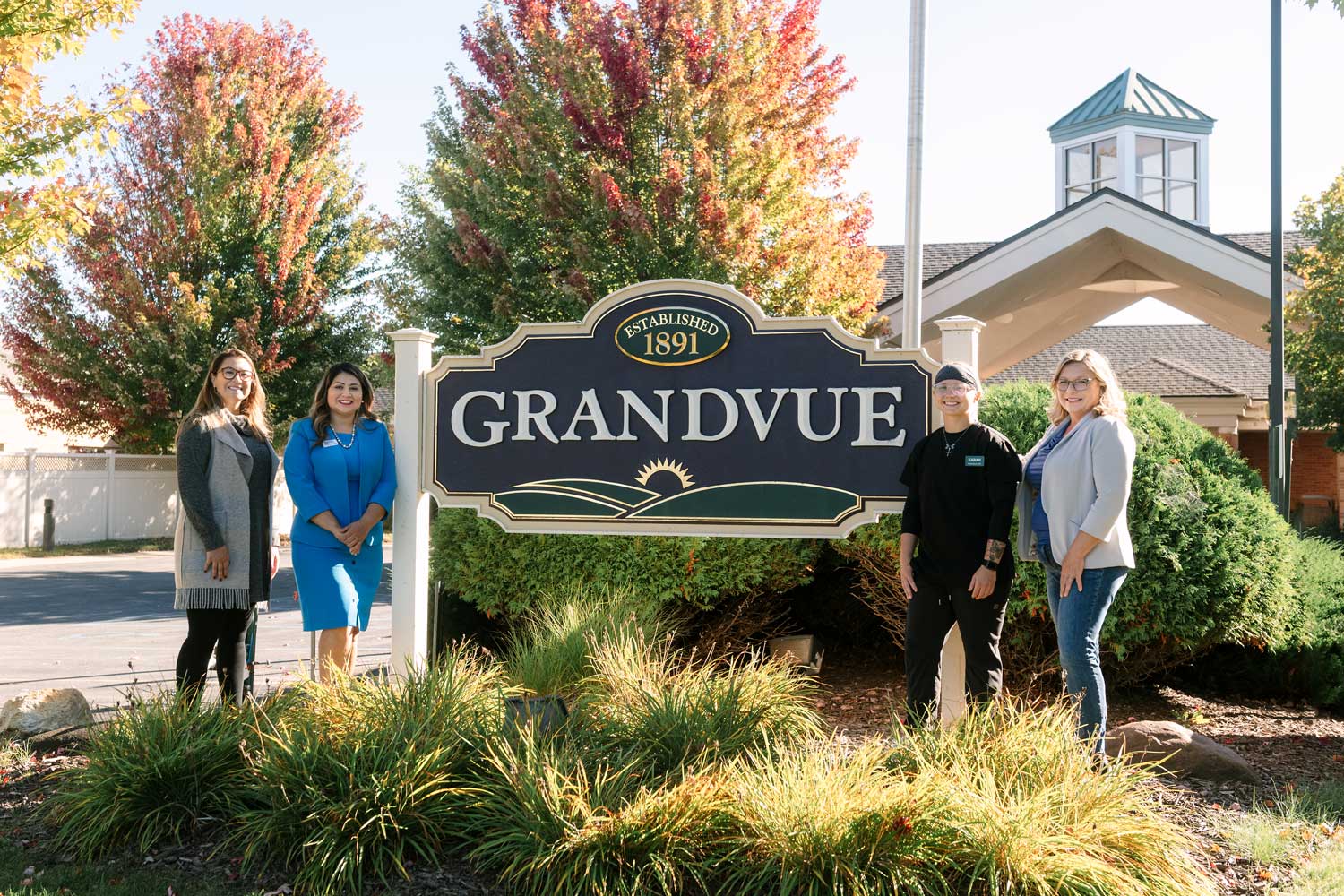 Four individuals stand beside the Grandvue Medical Care Facility sign in front of the building, representing NCMC and Grandvue’s new CNA Fast Track program partnership. From left: Jennifer Foley, Cassandra Hernandez, Karah Dunson, and Shannan Butler