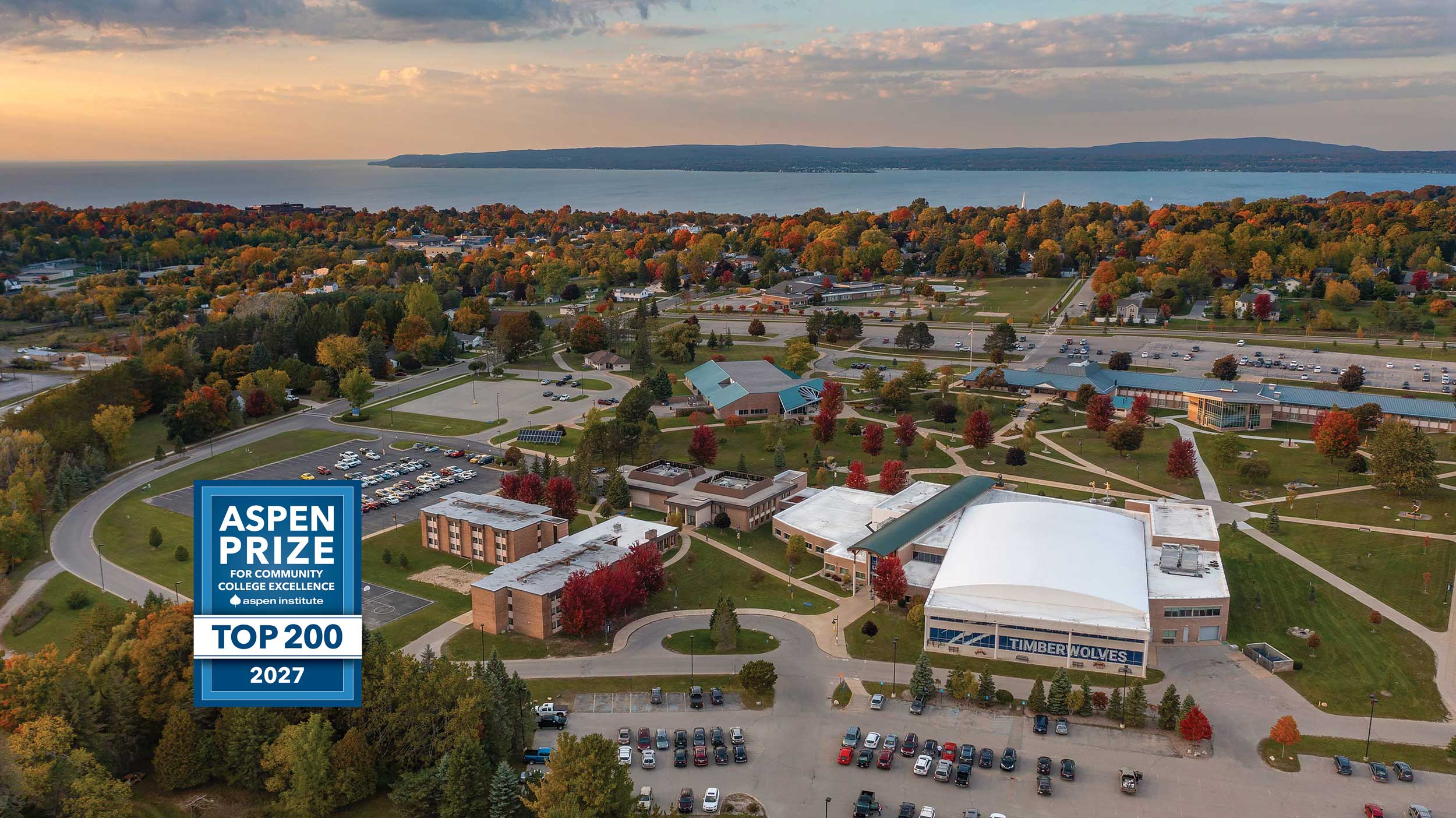 Aerial view of North Central Michigan College’s Petoskey campus in autumn, with red and orange trees surrounding campus buildings and walkways