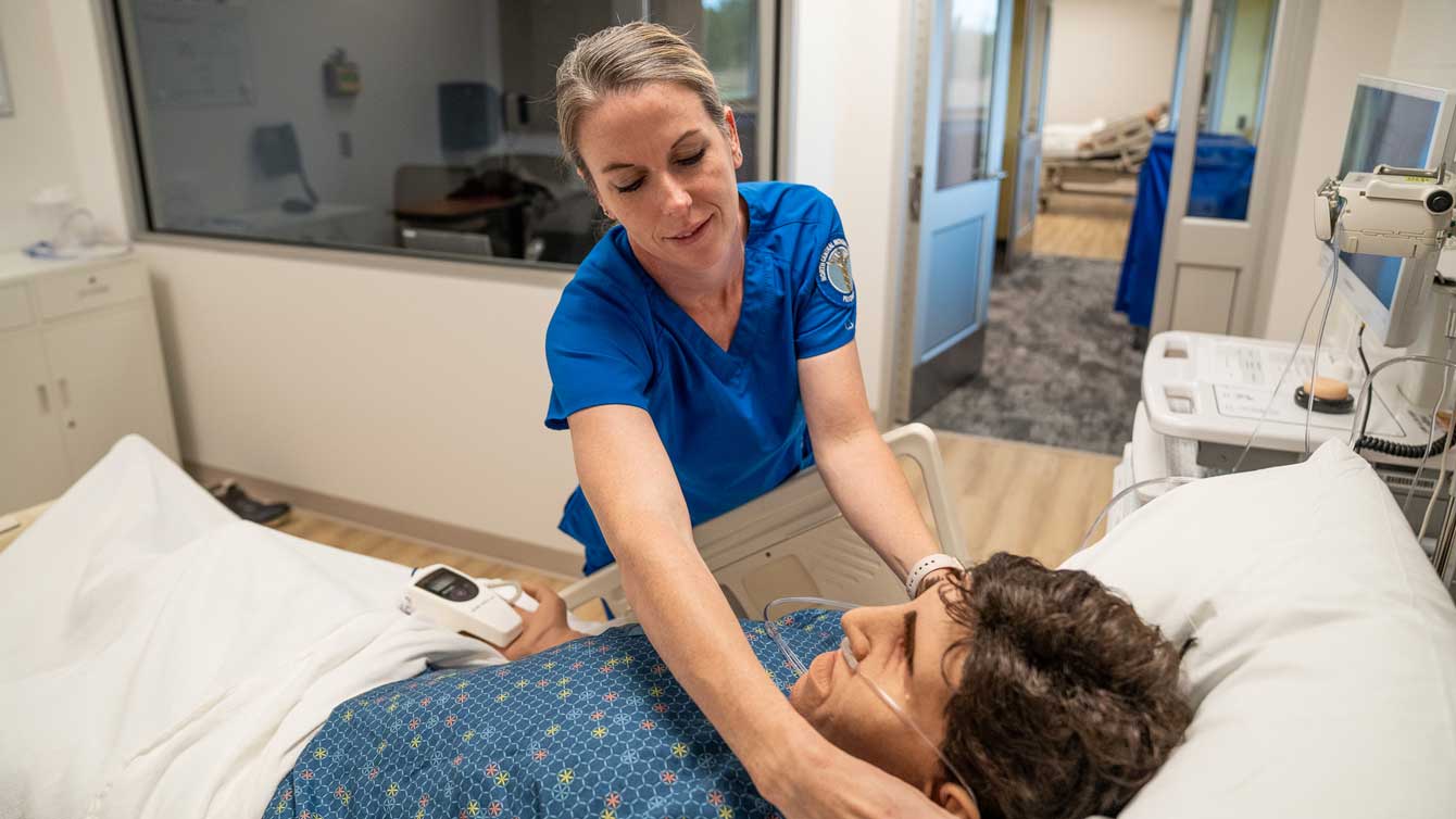 Nurse student working on SIM in classroom.