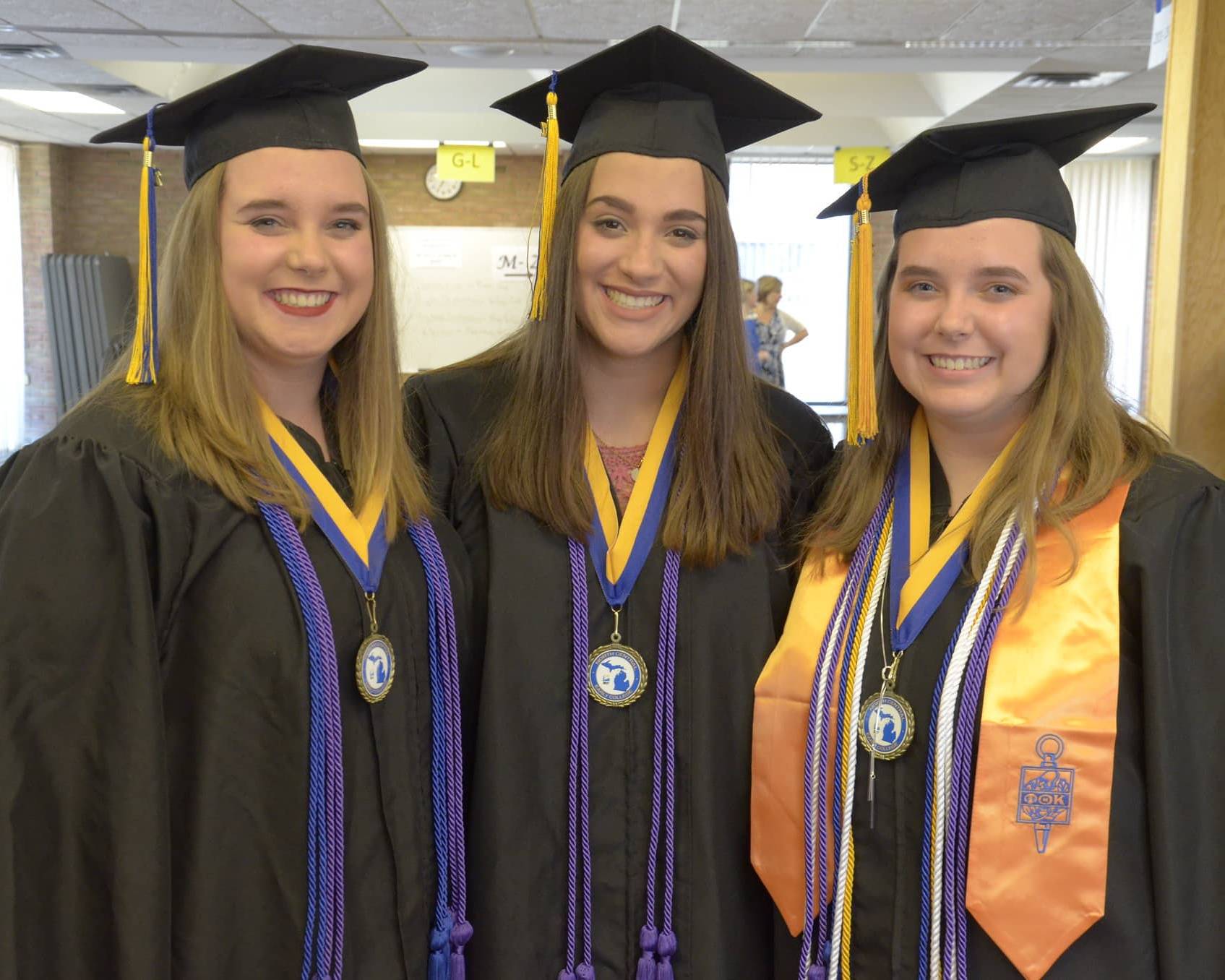 Three graduates, smiling